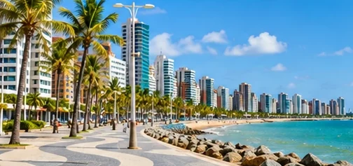 Calçadão da Beira-Mar de Fortaleza com coqueiros e prédios.